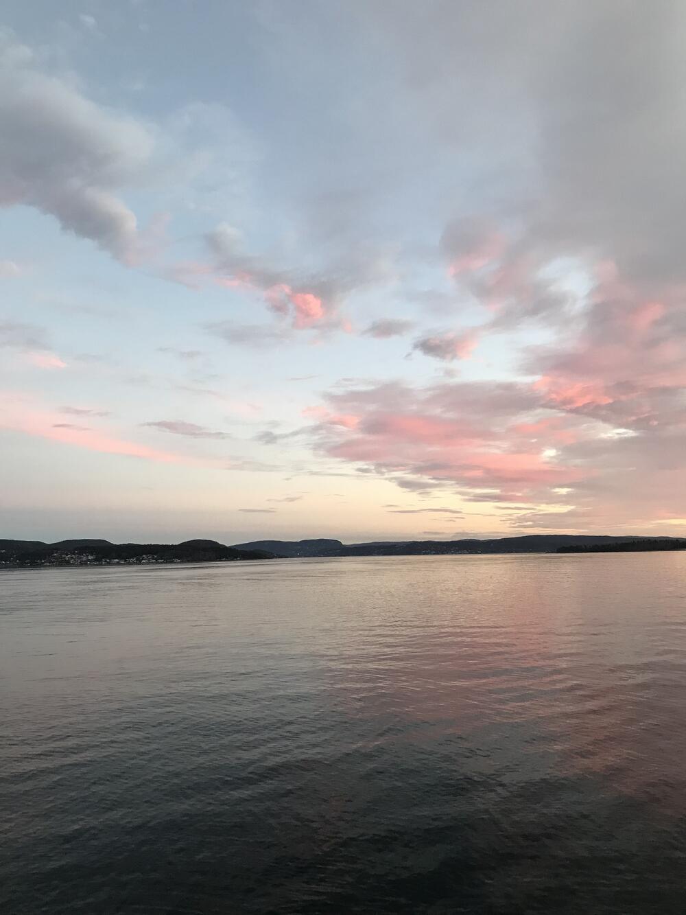 Himmel og hav i lyseblått og rosa, Langøya i bakgrunn, foto