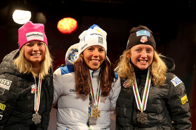 CHARLOTTE KALLA med VM-guldet på Medal Plaza i Falun tillsammans med tvåan Jessica Diggins (tv) och trean Caitlin Gregg. Foto/rights: MARCELA HAVLOVA/sweski.com