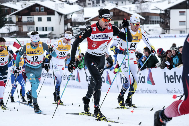 DARIO COLOGNA säkrade sig ett perfekt utgångsläge inför avslutningen av Tour de Ski. Daniel Richardsson (bakom) var stark 6:a i masstarten i Val di Fiemme, medan Oskar Svensson (bak till vänster) var näst bäste svensk som 16:e man. Foto: NORDIC FOCUS