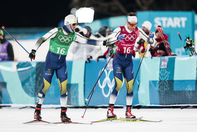 CALLE HALFVARSSON och Marcus Hellner växlar i OS-teamsprinten där dom missade medaljen och slutade 4:a. Nu kanske ingen av dom åker femmilen och Sverige grejar inte av att fylla kvoten. Pinsamt! Foto: NORDIC FOCUS