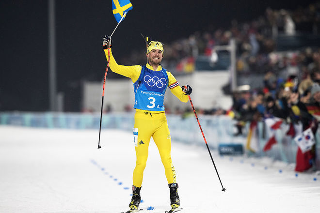 FREDRIK LINDSTRÖM hade god tid att jubla med den svenska flaggan på upploppet. Vilket galet slut på skidskytte i detta OS! Foto: NORDIC FOCUS