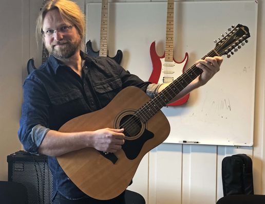 Anders Marius Blystad er rektor ved Hadeland kulturskole. På fritiden spiller han gjerne gitar. Foto: Kine Vik-Erstad ©Gran kommune Mann med gitar