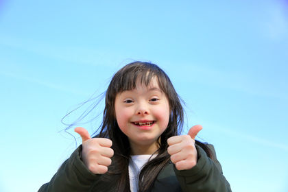 Portrait of little girl smiling on background of the blue sky