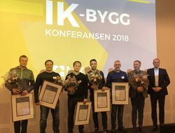 PRISDRYSS: Under konferansen deles IK-byggprisen i gull og sølv. Her er vinnerne av IK-byggprisen i 2018 samlet på scenen. Foto: Sindre Haarr