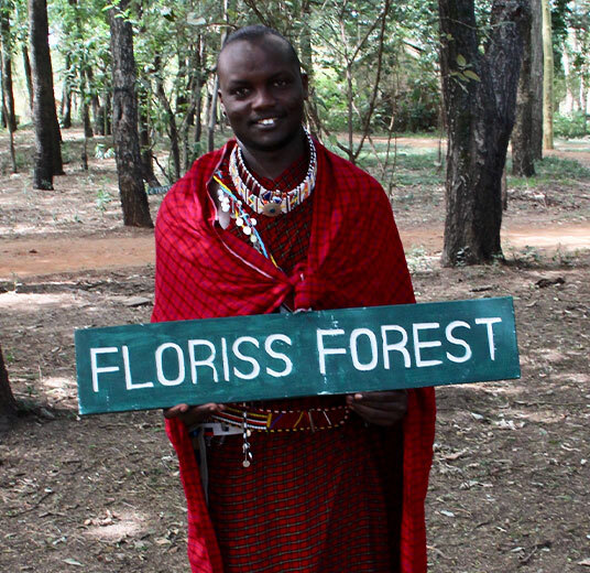 treplanting-i-kenya-masaimann-med-floriss-forest-skilt.jpg
