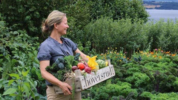 Dame som bærer kurv med grønnsaker