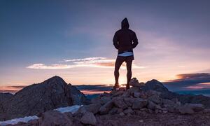 På toppen av fjellet med utsikt mot solnedgangen