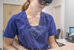 Fysioterapeut Anna Osen Byberg (med hololensbriller) samarbeider her med ortoped Ivar Hanssen på Helgelandssykehuset. Ortopeden kan se pasienten og samtidig gi instruksjoner til fysioterapeuten i sann tid. Foto: Helgelandssykehuset