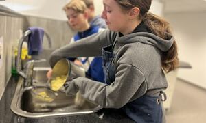 Gutt og jente som lager potetmos på skolekjøkkenet, Grua skole
