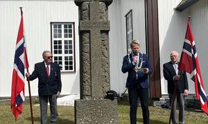 Ordfører Harald Tyrdal holder tale utenfor Lunner kirke 8. mai. Kjell Kristiansen og Ivar Myhrstuen holder flagg.