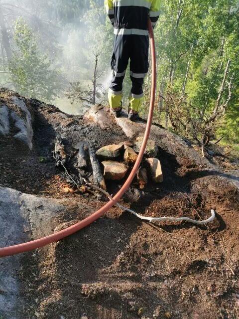 Brannmann som slokker brann i skog