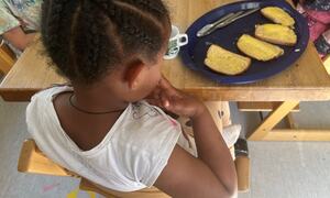 Jente som spiser ostesmørbrød i Gamleskolen barnehage