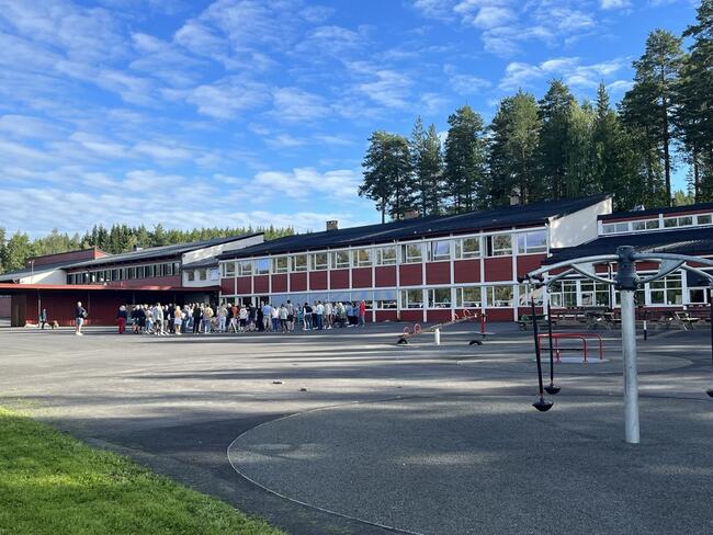 Harestua skole med skolegård i forgrunnen. Sommerbilde.