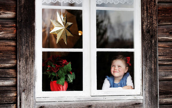 Jente som ser ut av et vindu