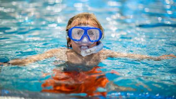 Jente med dykkebriller i basseng