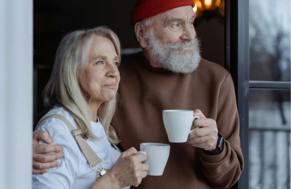 Eldre kvinne og mann i et vindu med kaffekopp