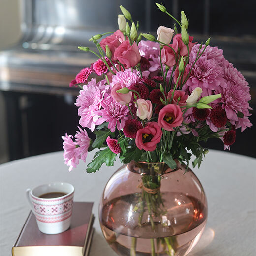 En flott bukett med tre ulike blomster i rosa-toner i vase