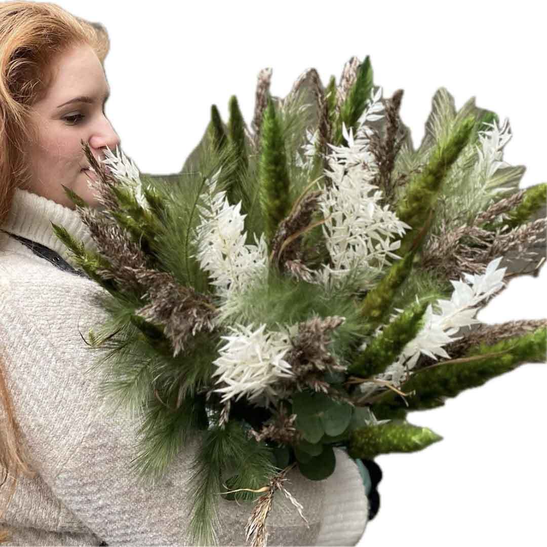 En av våre fantastiske kvinnelige ansatte som holder en bukett med hvite blomster