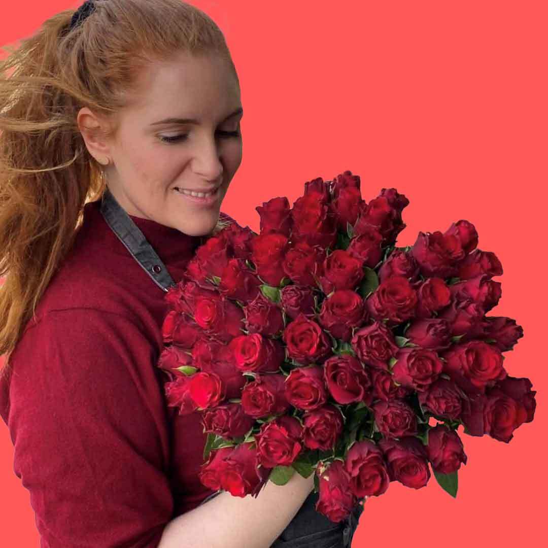 En av våre fantastiske kvinnelige ansatte som holder en bukett med røde roser