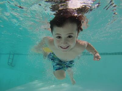 Barn som svømmer under vann