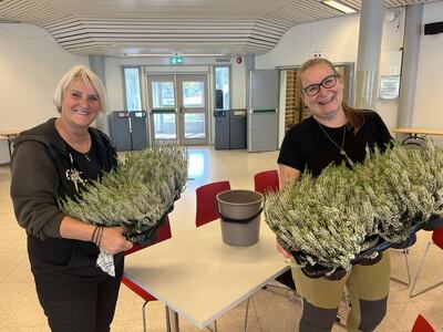 Toril Svendsbråten og Mona Haugen i full gang med å pynte bord med blomster i foajeen på Lunner ungdomsskole