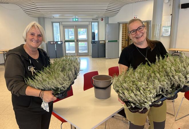Toril Svendsbråten og Mona Haugen i full gang med å pynte bord med blomster i foajeen på Lunner ungdomsskole