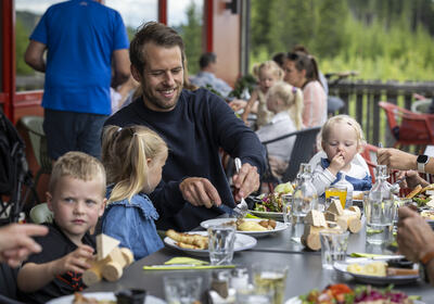 Familie spiser mat ute på ved PRøysenhuset