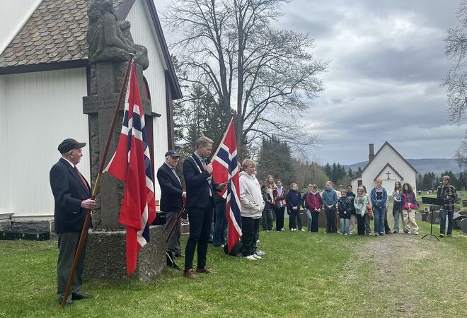 Ordfører holder tale, flaggbærer og elever foran Lunner kirke