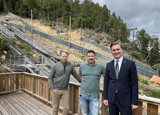 Tyrdal, Myrdal og Snortheim står foran hoppanlegget i Grua vinterpark. Bildet er tatt i juni.