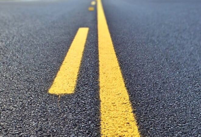 Nærbilde av asfalt med gul midstripe