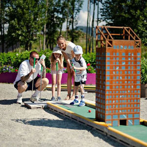 Familie som spiller minigolf