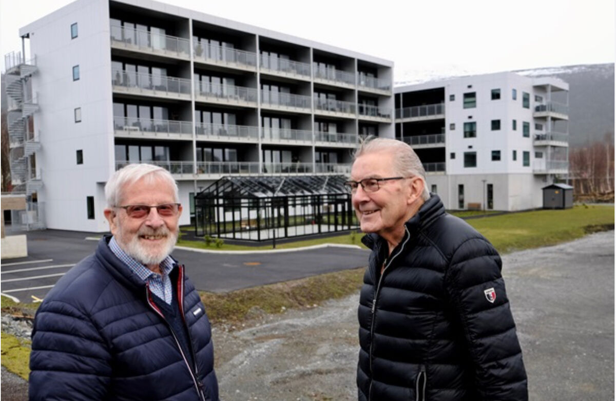 To eldre menn med blokkbebyggelse i bakgrunnen