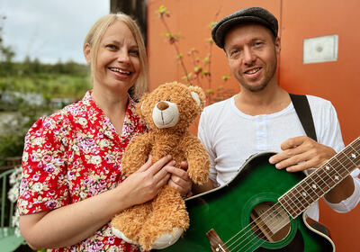 Prøysenhusets formidlere utendørs med bamse og gitar