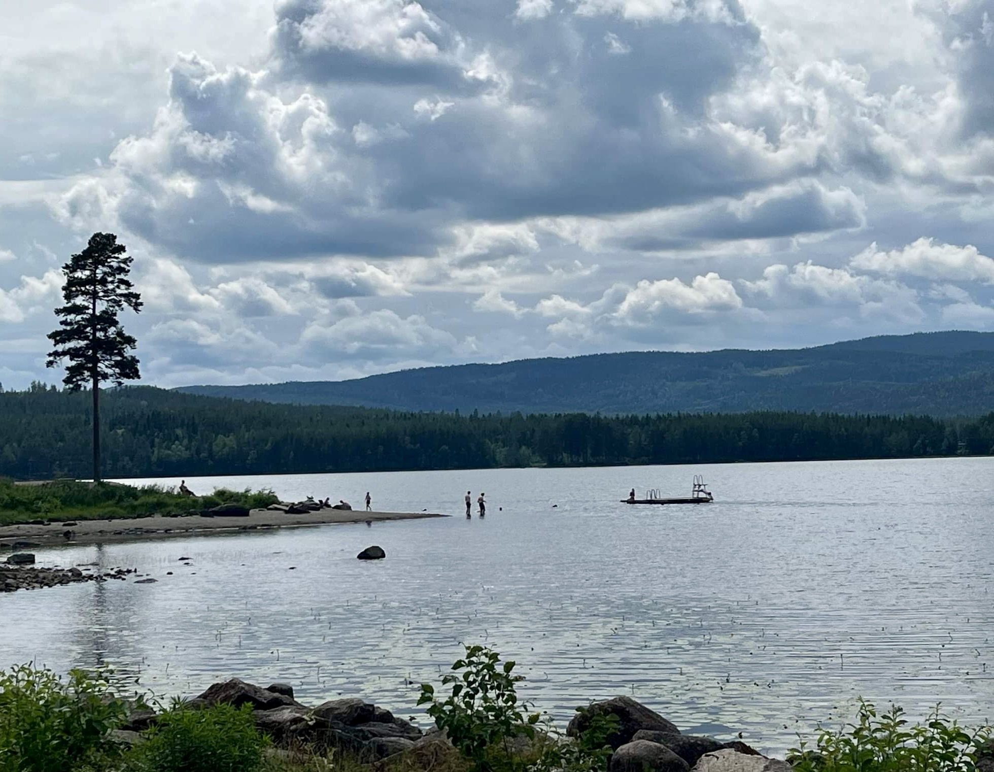 Harestuavannet sett fra Harestua kro med stupetårn og noen som bader i vannet