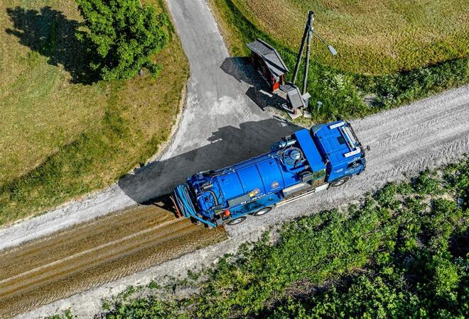 Tømmebil fra NORVA sett ovenfra i et veikryss i landlig område