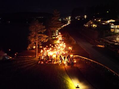 Dronefoto som viser mange folk med fakler og lys på Gramerrtangen