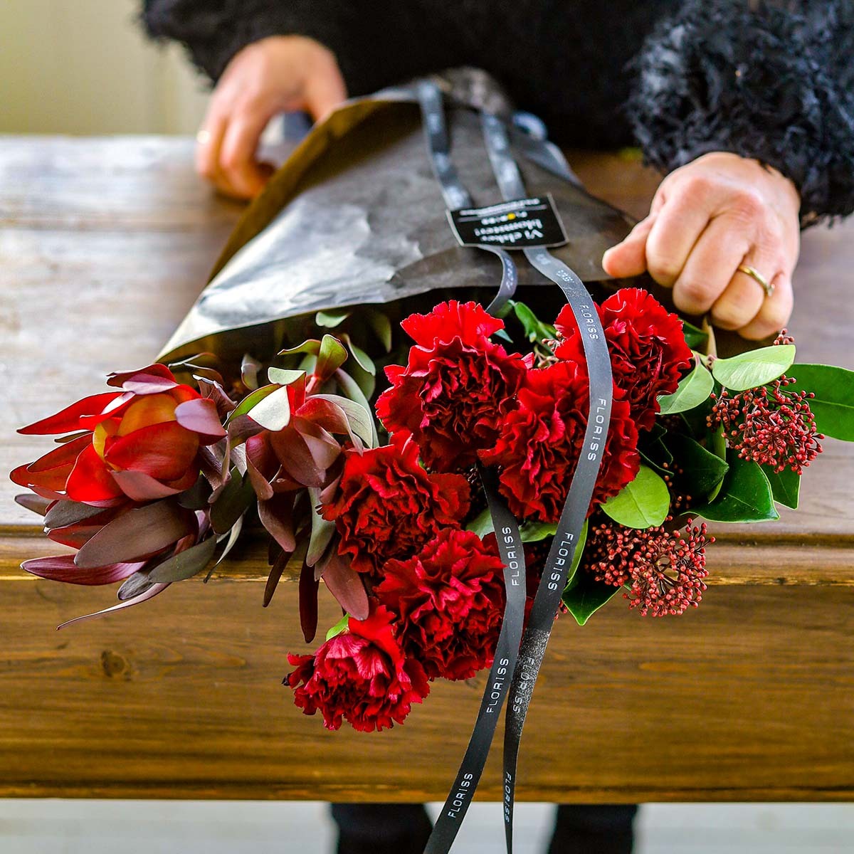 Nellik, skimmia og leucadendron i forpakning