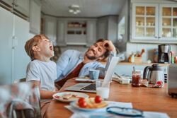 Et av bilde av en pappa og et barn ved frokostbordet illustrerer gode boliger.