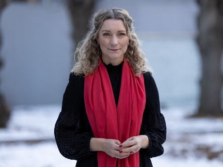 Karianne Tung utendørs med mørk jakke og rødt skjerf.