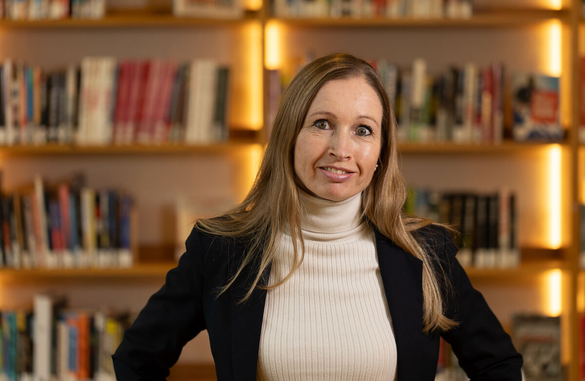 – Biblioteket er gratis, åpent og menneskelig. I en digital tid er det kanskje nettopp derfor vi trengs mer enn noen gang, sa Julie Andersland, direktør for Etat for bibliotek og kultur i Bergen kommune. Foto: Ragnar Rørnes Kvinne med langt blondt hår med bøker i bakgrunnen