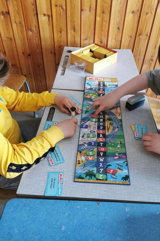 Bildet viser et bord med to unger på hver sin side som sammen spiller et spill.