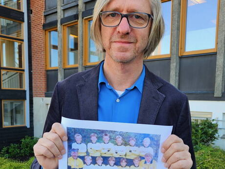 Daniel holder opp et bilde av fotballaget han var med på på 80-tallet.