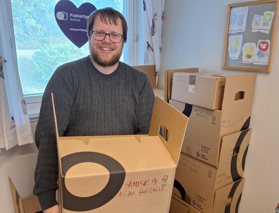 Bilde av ansatt ved Kvæfjord bibliotek som holder en flytteeske