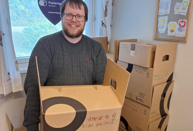 Bilde av ansatt ved Kvæfjord bibliotek som holder en flytteeske