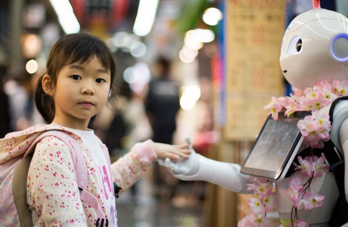 Liten japansk eller kinesisk jente hilser på robot.