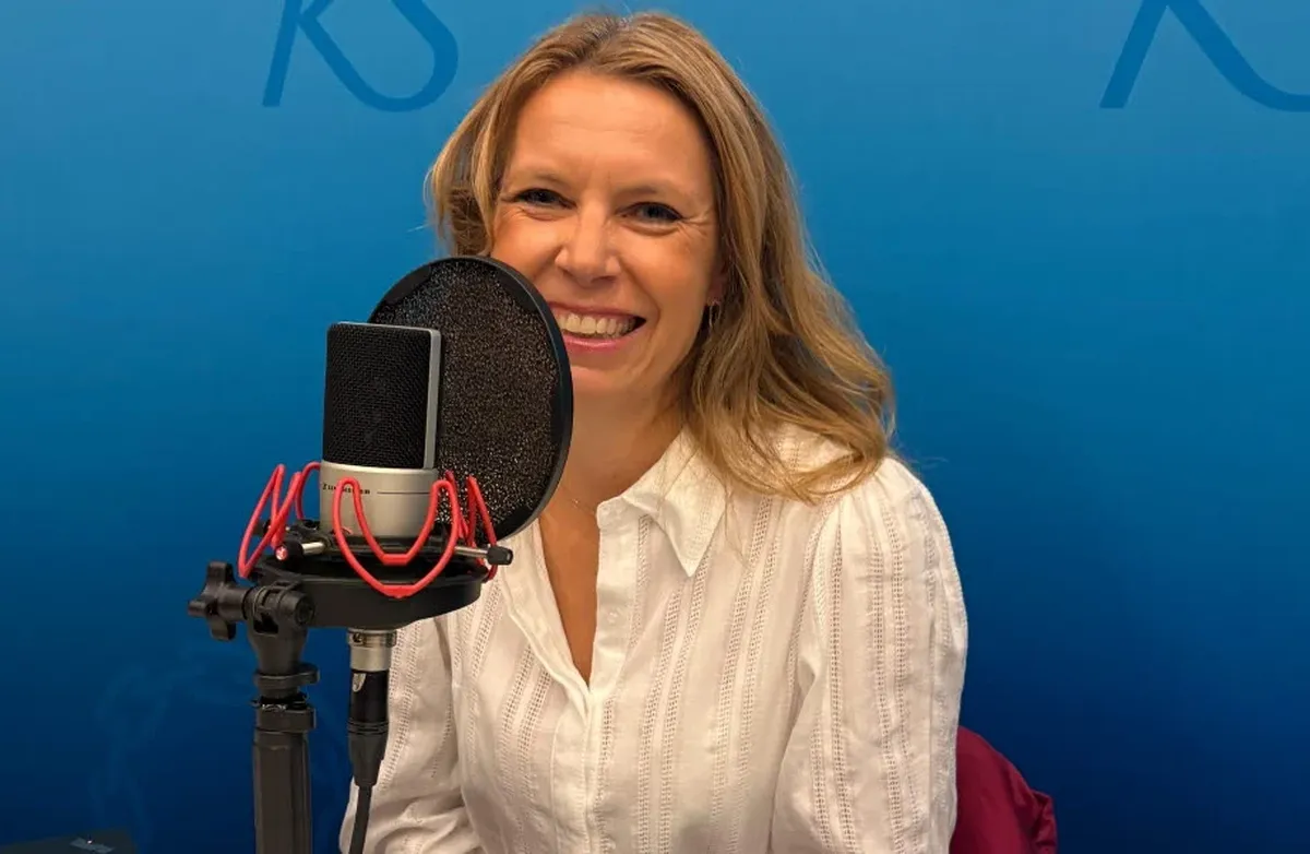 Smilende kvinne med langt lyst hår i studio, blå bakgrunn