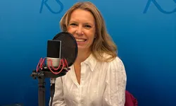 Smilende kvinne med langt lyst hår i studio, blå bakgrunn