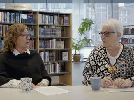 Formannskapssekretær Trude Paulsen (t.v) og eldrerådsleder Kari Ørnø og i Indre Østfold kommune sitter på et bibliotek.