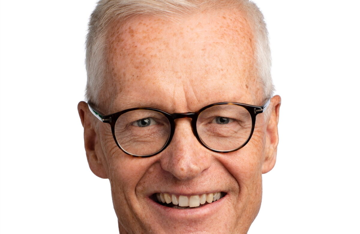 Jørn Leonardsen er IT-direktør i Skatteetaten. Foto: Skatteetaten. Kort grått hår, blå skjorte, lys brun dress, blå øyne, smiler