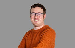 – Aldersvennlige nabolag blir til når innbyggerne leder an, tjenestene flytter seg nærmere folk, og alle parter deler både ansvar og avgjørelser, avsluttet Mark Hammond. Foto:  Manchester School of Architecture Ung mann med oransje genser, smiler, armene i kors